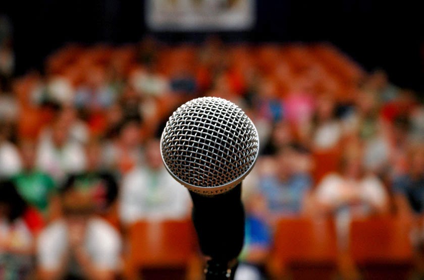 Microfone e público aguardando orador
